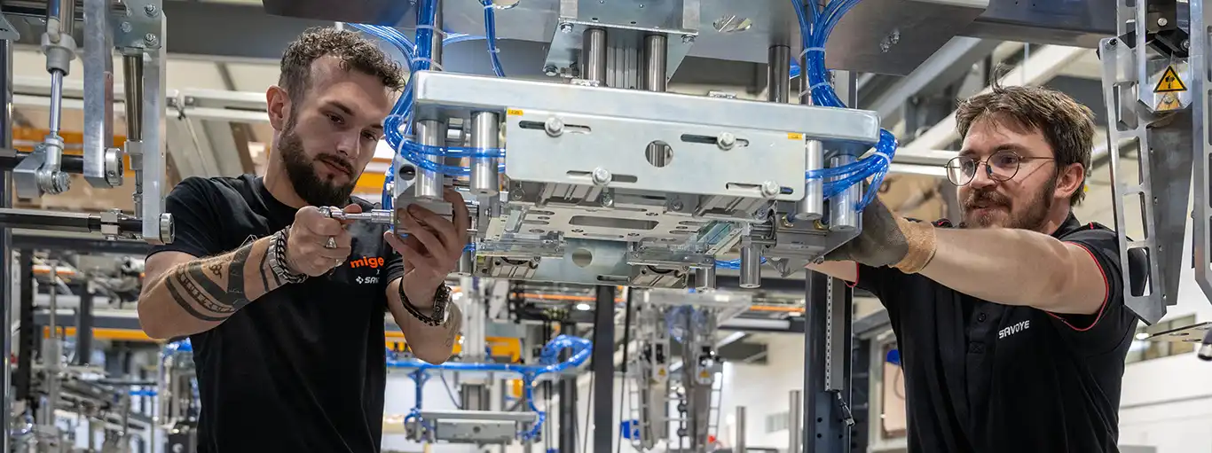 Collaborateurs Migen et SAVOYE assurant la maintenance d'un machine SAVOYE